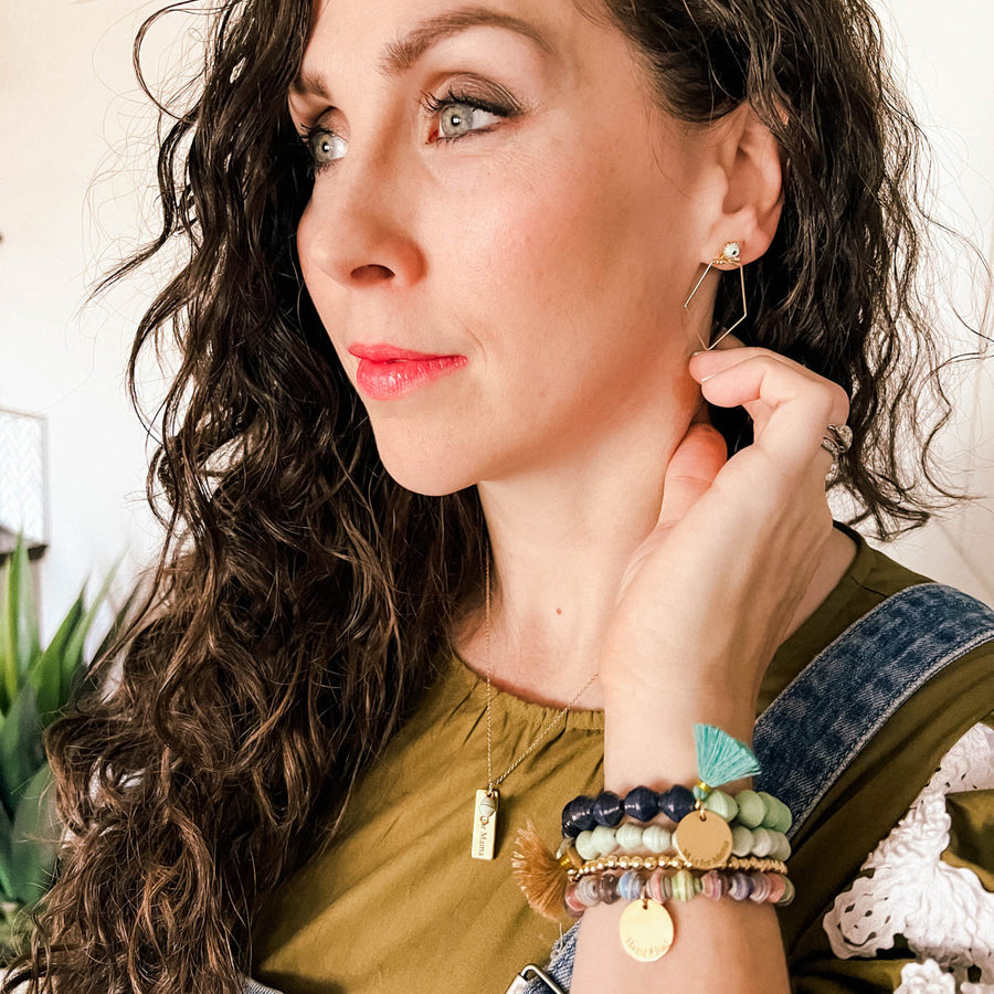 Ethically made bracelets that say M is for Mama and Hard does not equal badin navy, mint, multi colored, gold, charms, and tassels