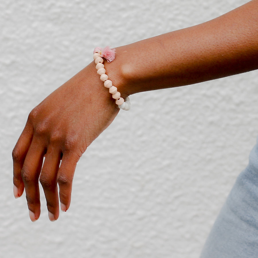 The Jetsetter Tassel Bracelet: pink handmade paper bead bracelet with tassel made by artisans in the Horn of Africa. Sustainable, Artisan-Made And Ethically Sourced