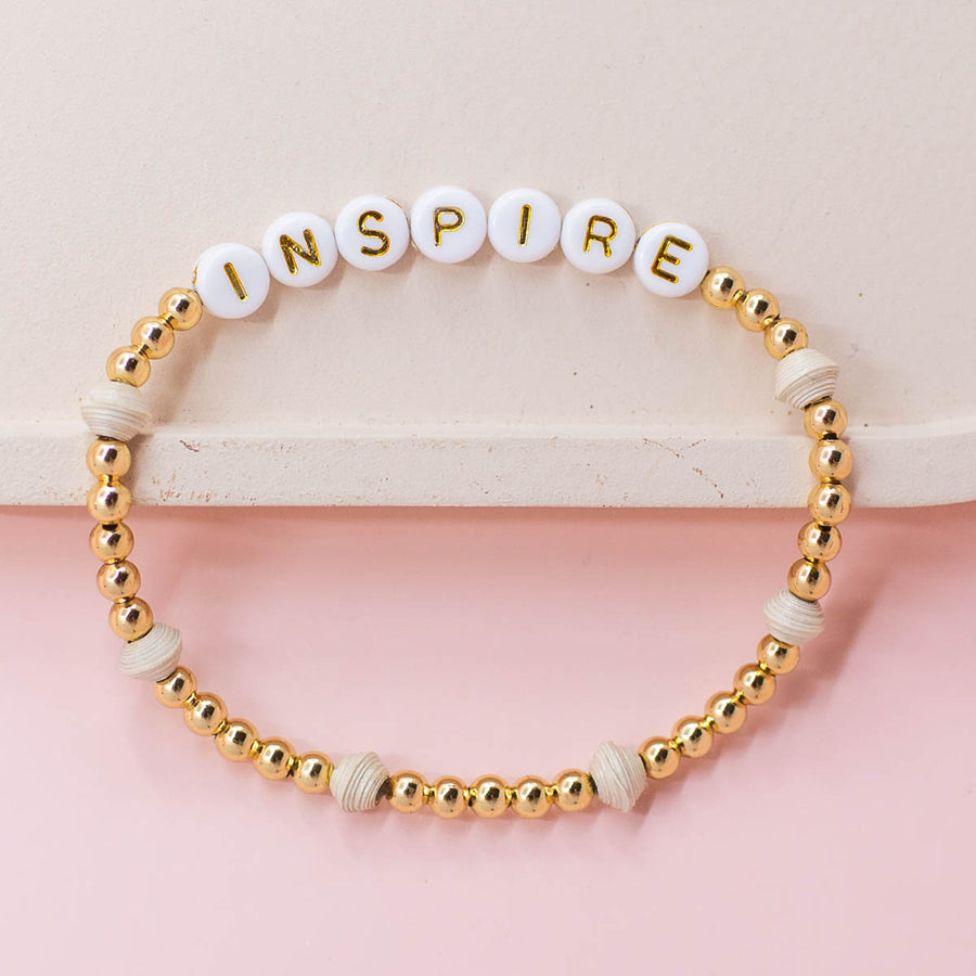 Ethically made stack of letter bead bracelets with word inspire