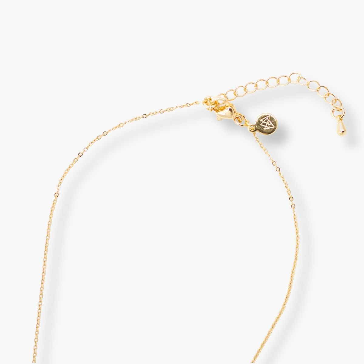 Ethically made 18k gold plated necklace with handmade paper bead and a bar pendant engraved with the phrase M is for Mama close up shot of back of necklace
