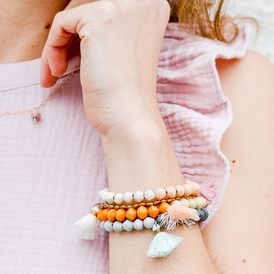 The Jetsetter Tassel Bracelet: pink handmade paper bead bracelet with tassel made by artisans in the Horn of Africa. Sustainable, Artisan-Made And Ethically Sourced